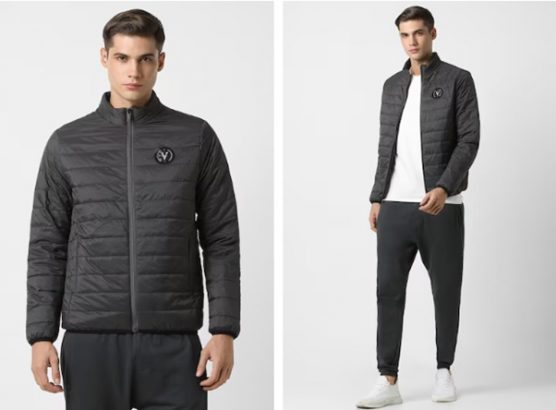 Man in a black quilted jacket, white shirt, black pants, and white sneakers.