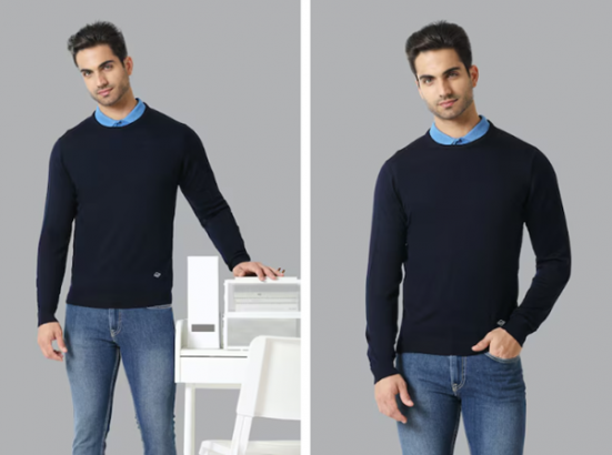 Man in dark sweater and jeans standing by a table with a chair and printer.