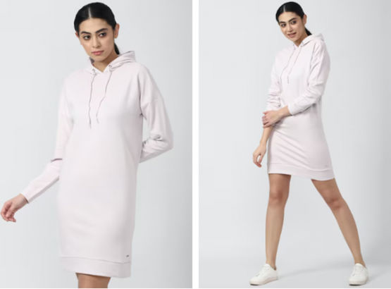 Woman in a light pink hoodie dress and white sneakers, standing in two poses against a gray background.