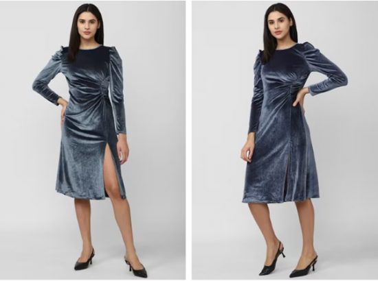 Satin or silk gowns: A person showcasing a blue velvet dress with a thigh-high slit, paired with black heels.
