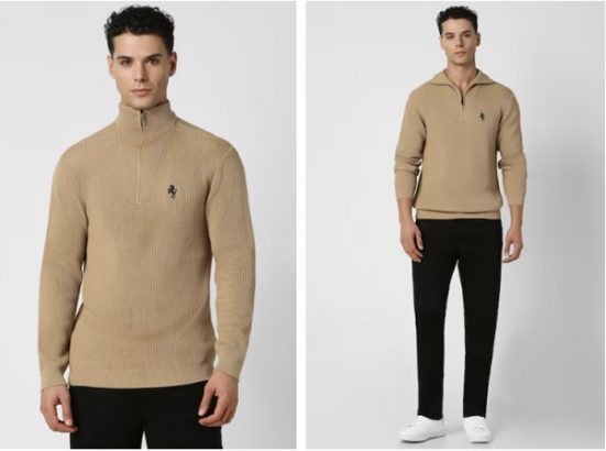 a man wearing a tan sweater and black pants
